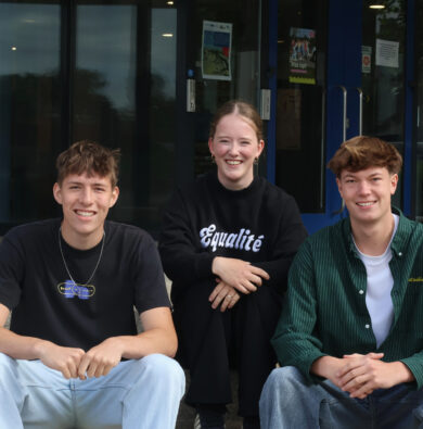 Suze, Dylan en Joris zitten op de trap voor het gemeentehuis